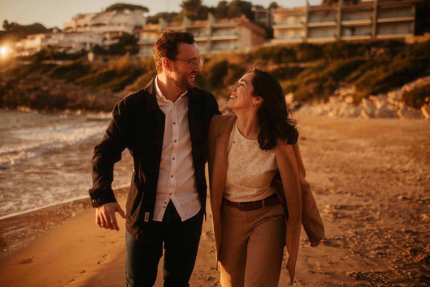 Pareja caminando por la orilla al atardecer en sesión romántica en Tarragona