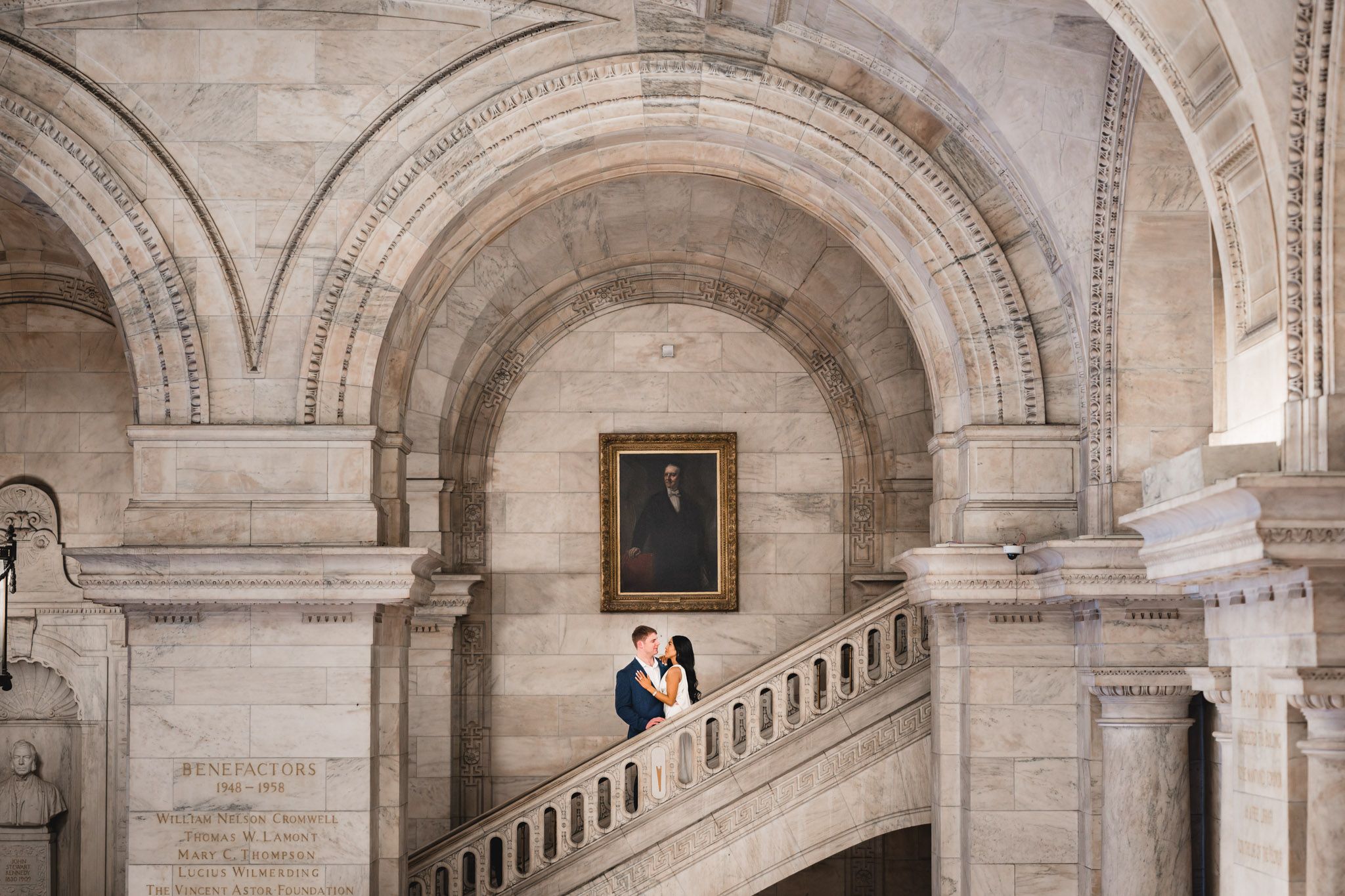 Romantic scene unfolds beneath historic stone arches with elegant architectural elements.