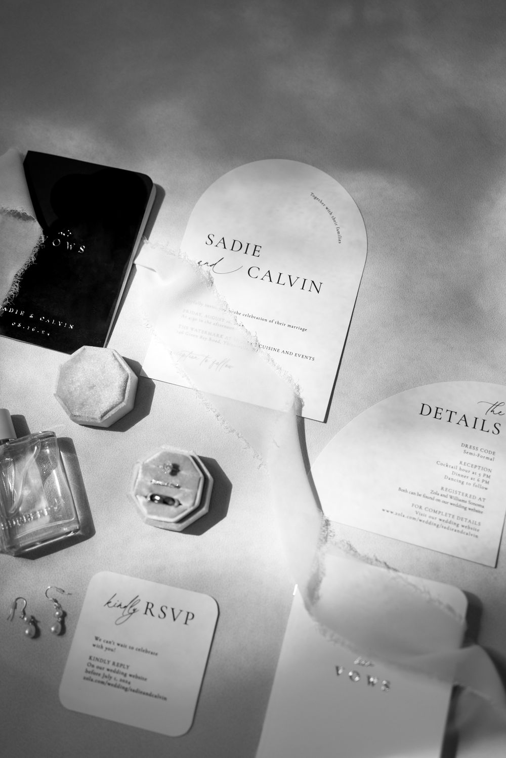 Elegant black and white business cards and stationery pieces arranged on a light surface with soft shadows.