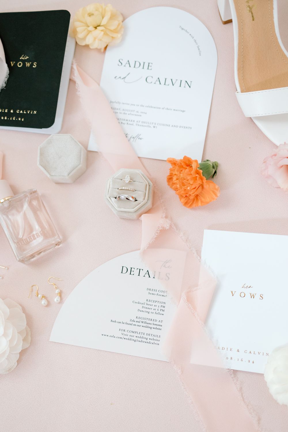 Minimalist wedding stationery suite in white and blush pink with floral accents and perfume bottles.