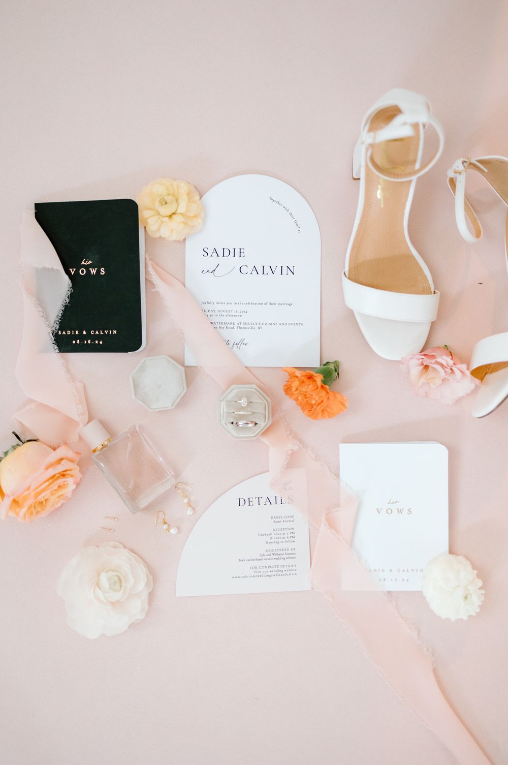 Wedding invitation suite with white stationery, peach and cream roses, and elegant white bridal sandals on blush background.