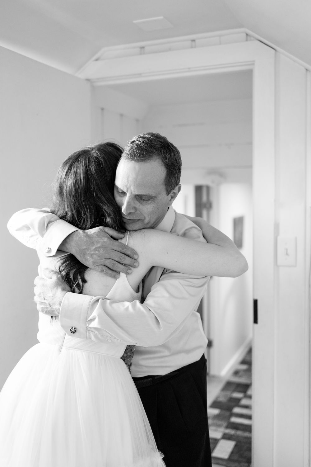 A series of black and white photos showing two people embracing in an intimate dance pose in a bright white room.