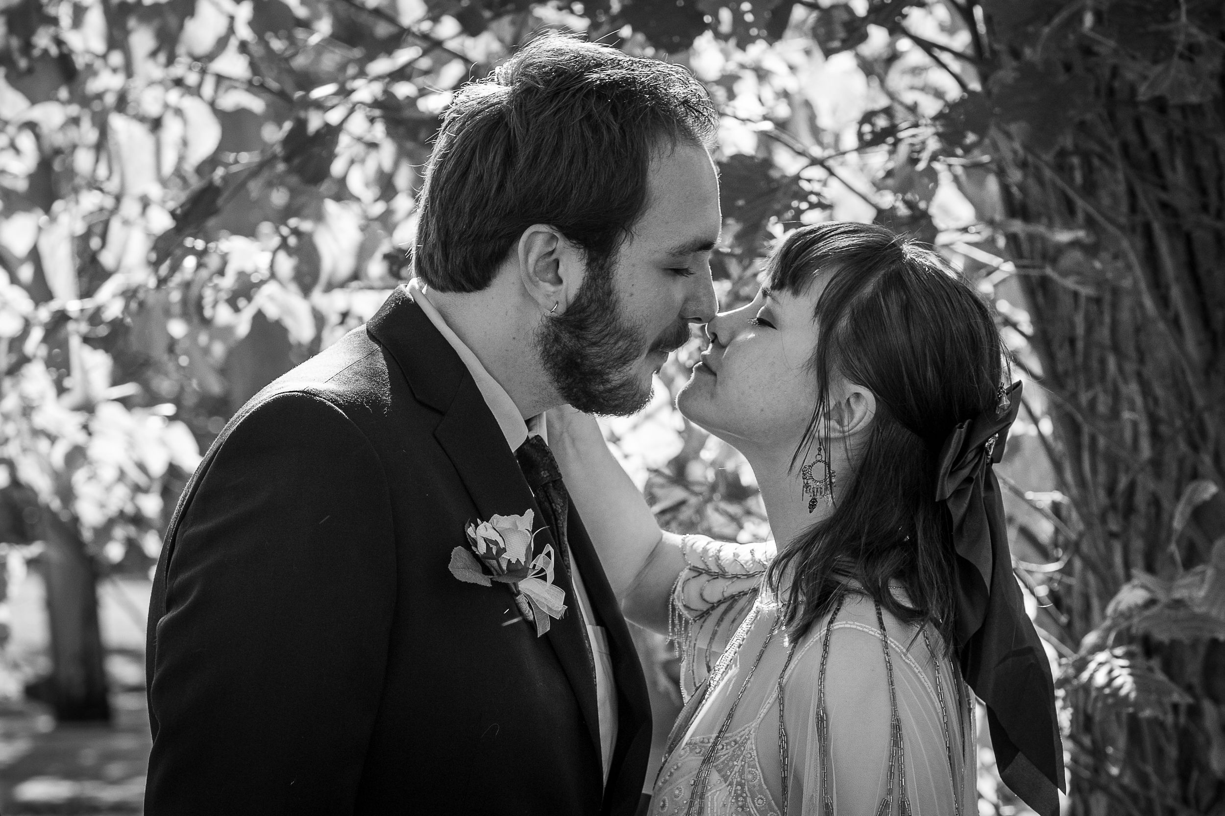 A series of romantic black and white wedding photos showing intimate moments between a couple in an outdoor setting.