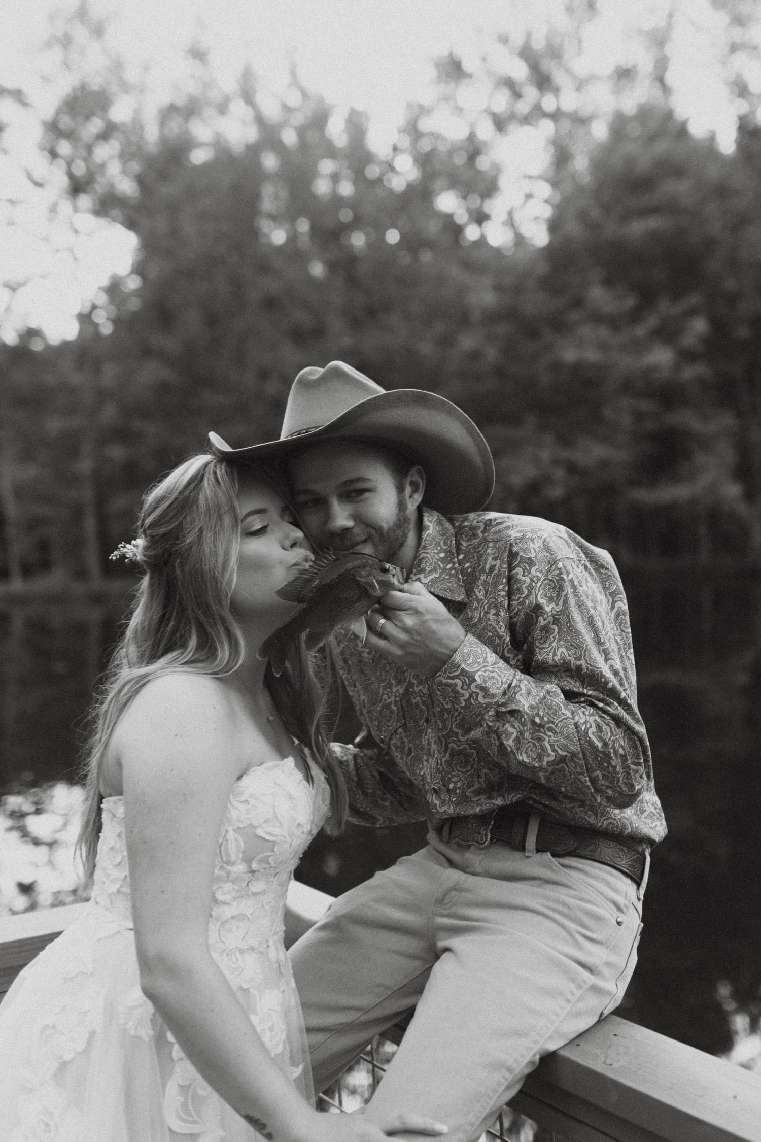 Photograph of bride and groom kissing a fish at the barn at big oak in franklin Georgia