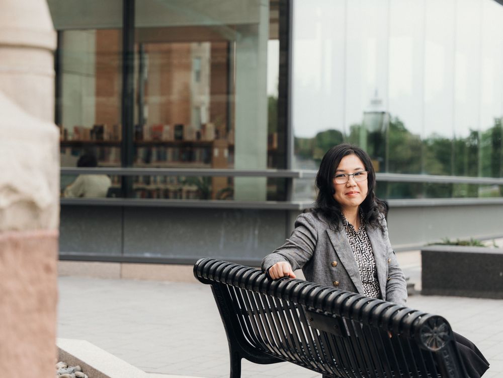 Professional portrait session against modern architecture with industrial seating.