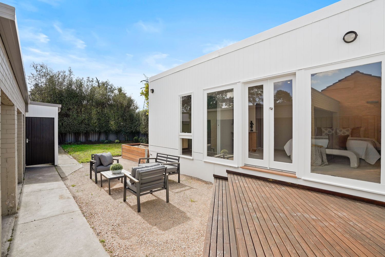 Outdoor patio area with wooden decking and comfortable seating furniture.