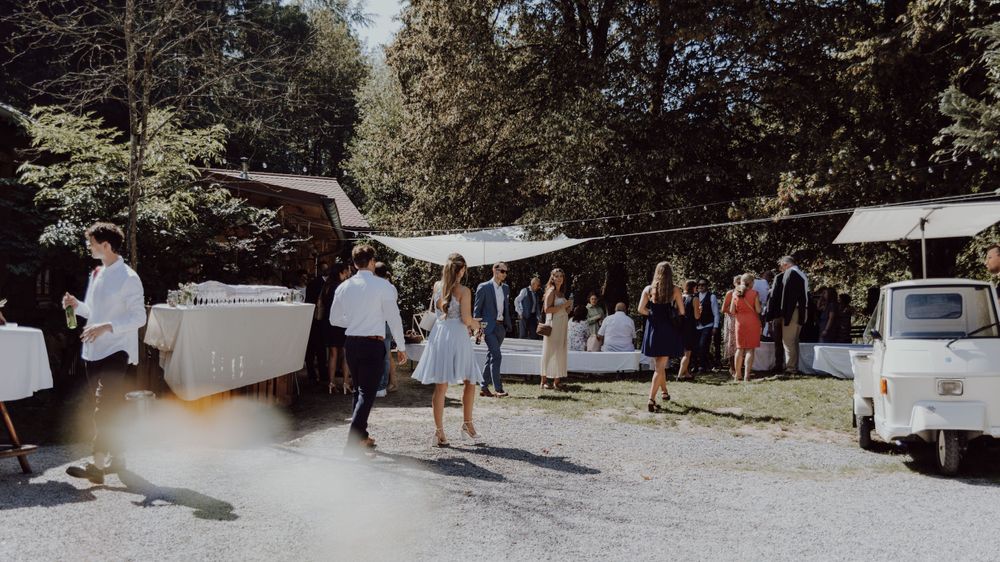 Outdoor wedding reception with food trucks and mingling guests.
