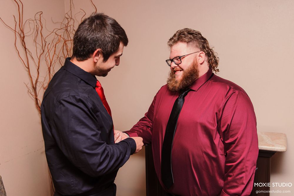 Two people in business attire engaged in an animated discussion in an office hallway.