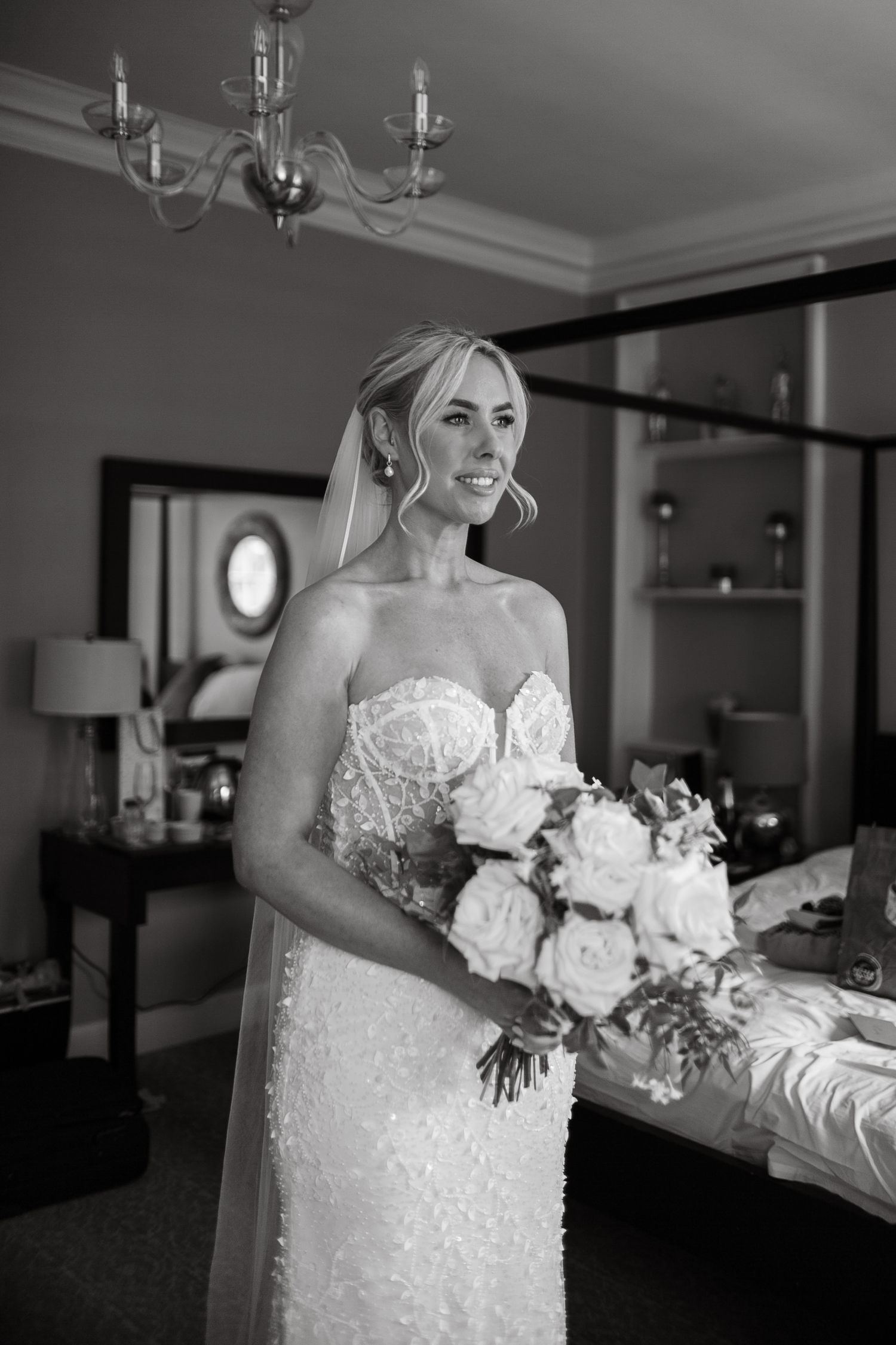 Close-up details of an elegant white lace wedding dress with floral bouquet.