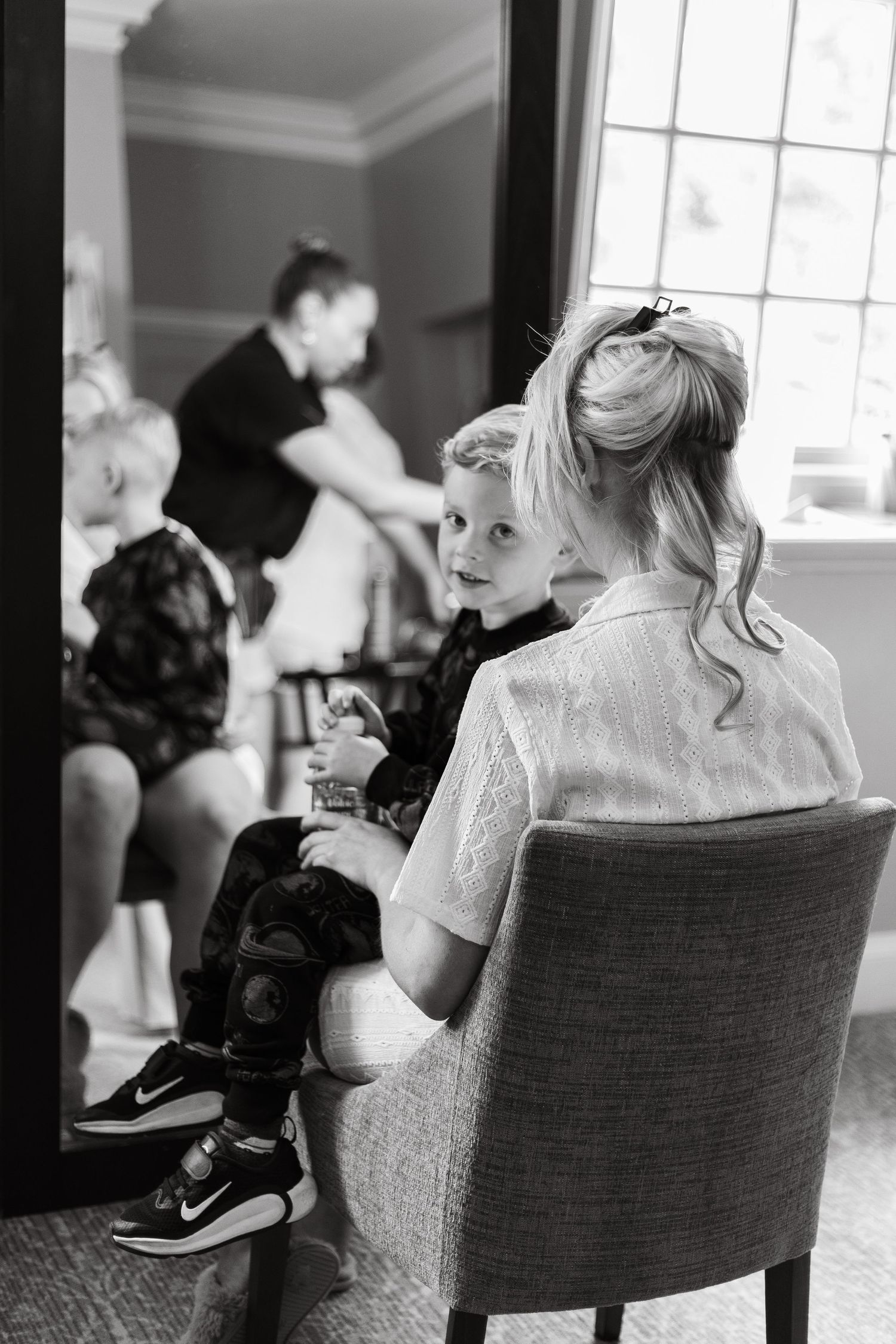 Black and white photo of wedding preparations in an elegant indoor setting.