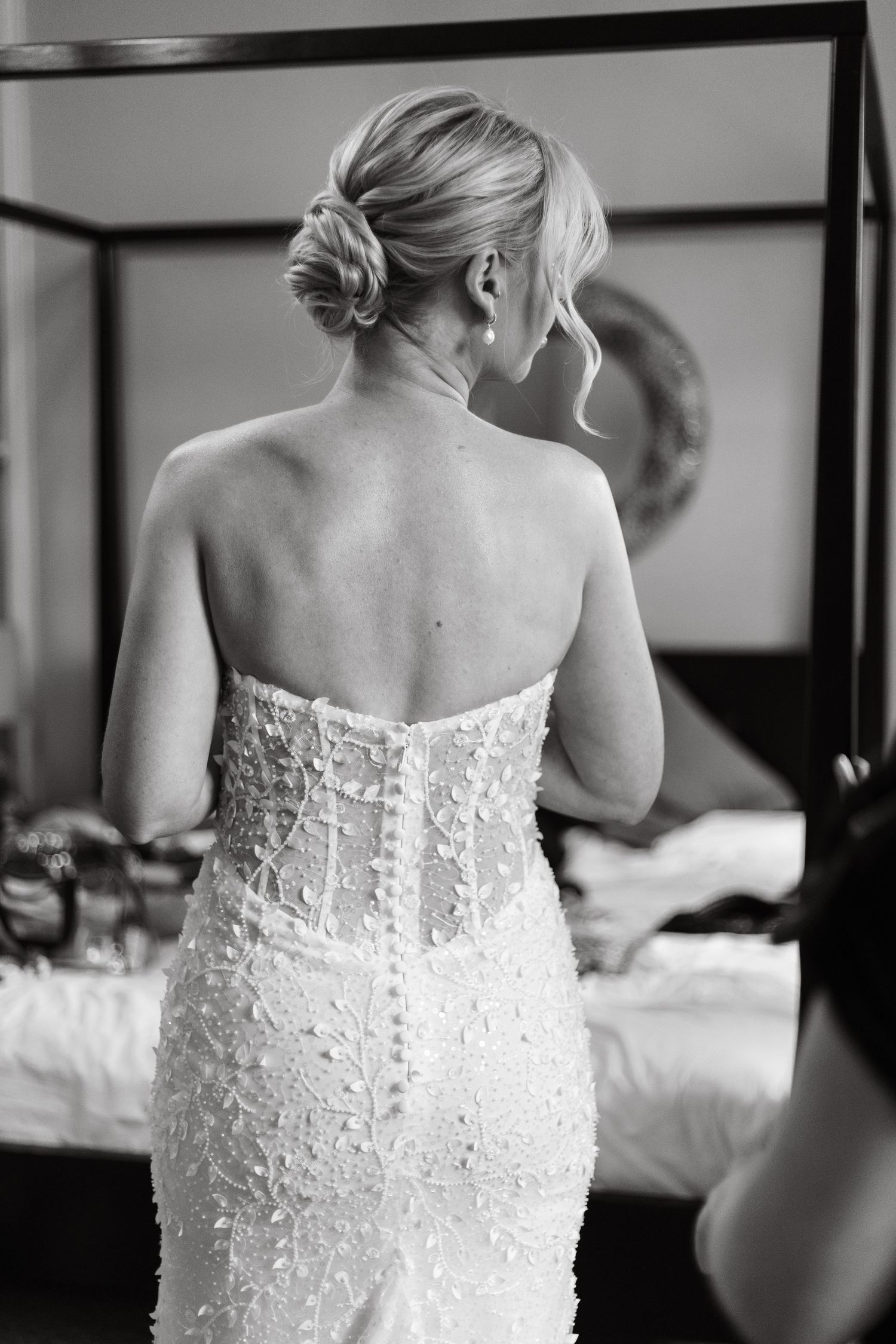 Back view of bride in fitted lace wedding gown with elegant updo hairstyle.