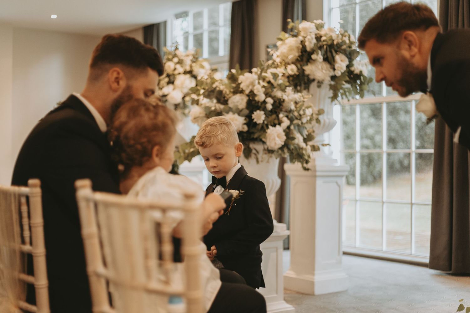 Elegant wedding venue decorated with white floral arrangements and soft lighting.
