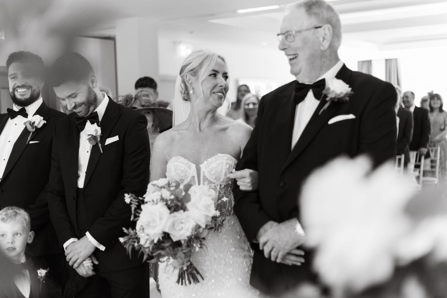 Black and white photo capturing emotional reactions during a wedding ceremony.
