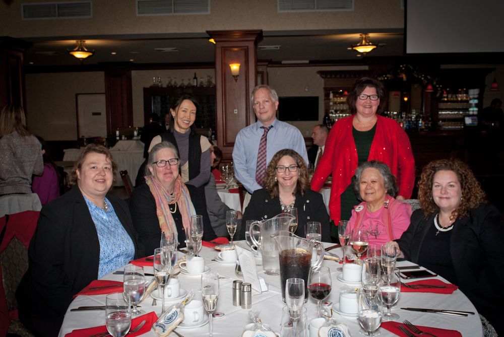 A group of people seated around an elegant dining table at a formal dinner event.