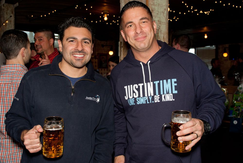 Two friends holding beer glasses at a casual holiday gathering.