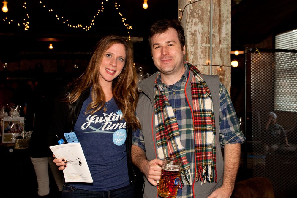 A couple posing together at a casual event with string lights in the background.