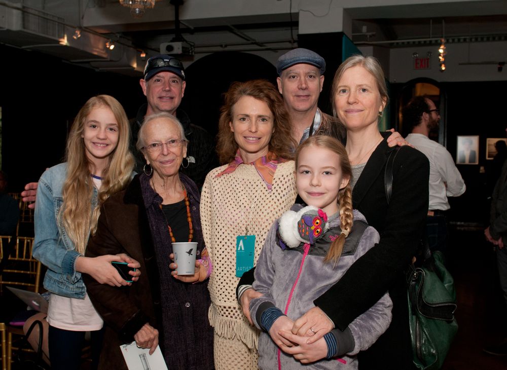 A family group gathers for a casual photo at an indoor event space.