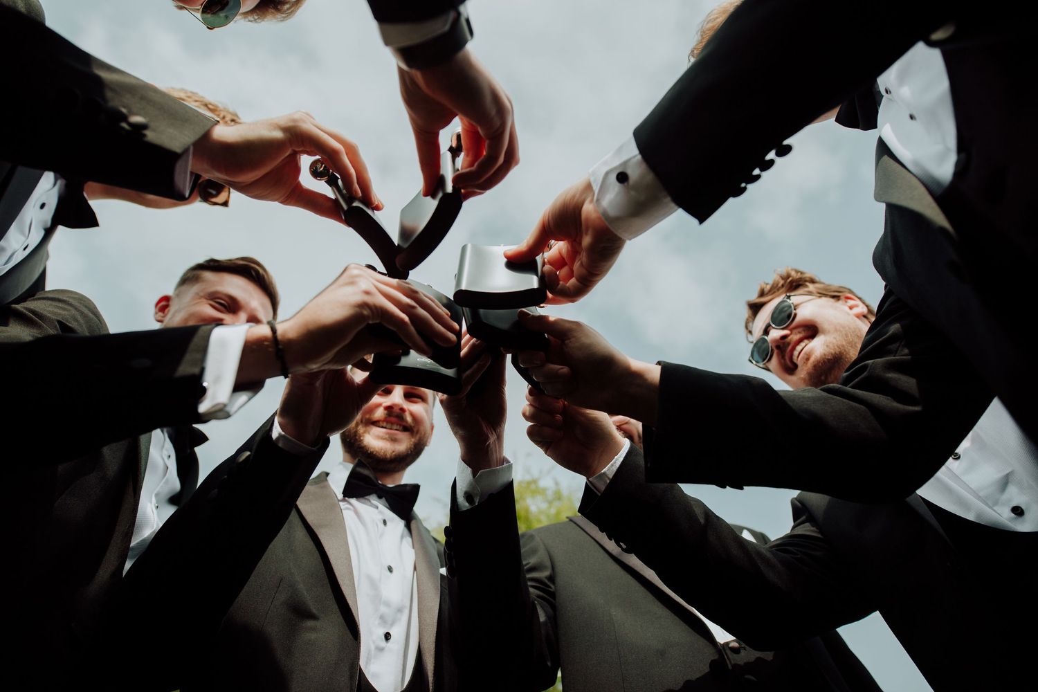 Looking up at a group in formal wear clinking champagne glasses together in celebration.