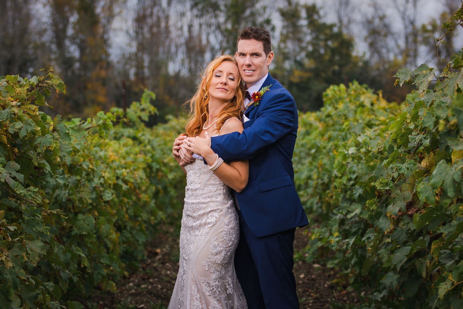 Romantic embrace in vineyard at sunset with elegant formal attire.