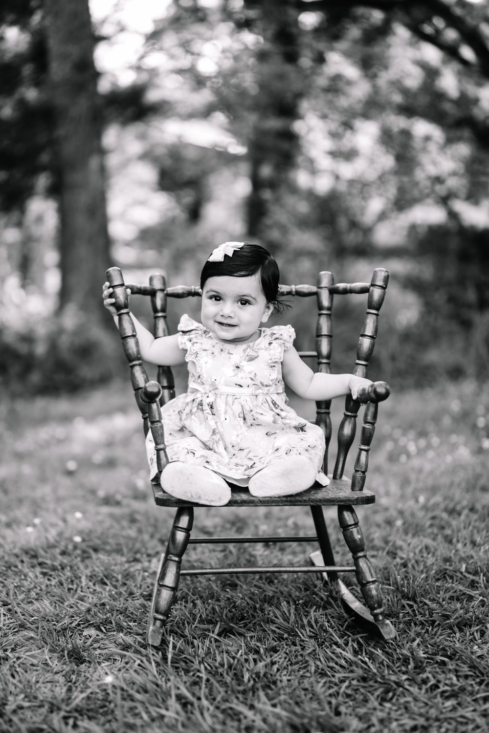 A mom and dad with their 11 month old daughter sitting on a rocking chair