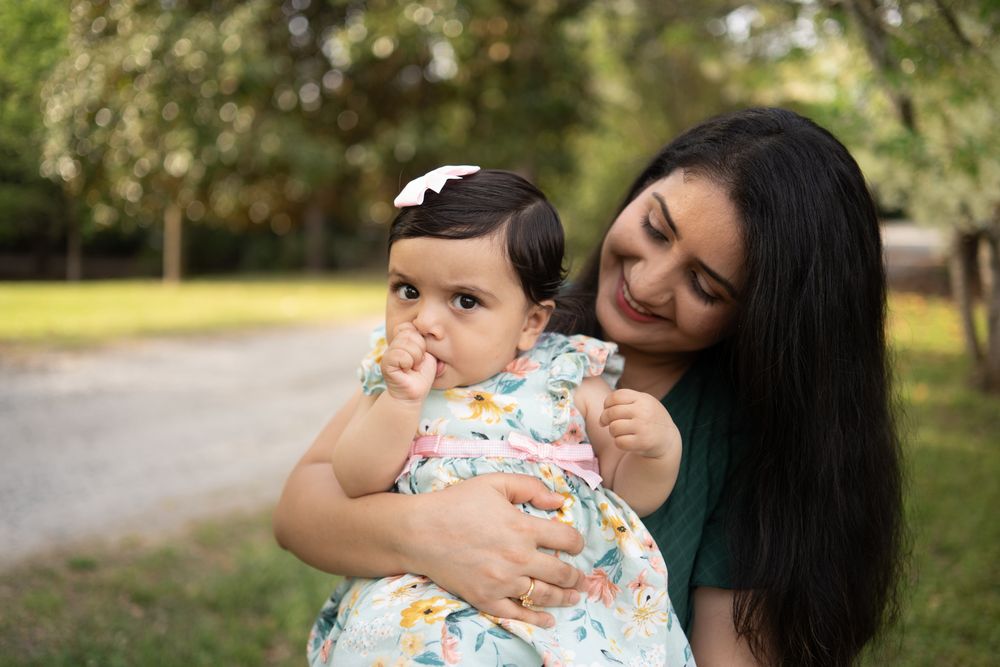 A mom and her 11 month old daughter looking sweetly at her