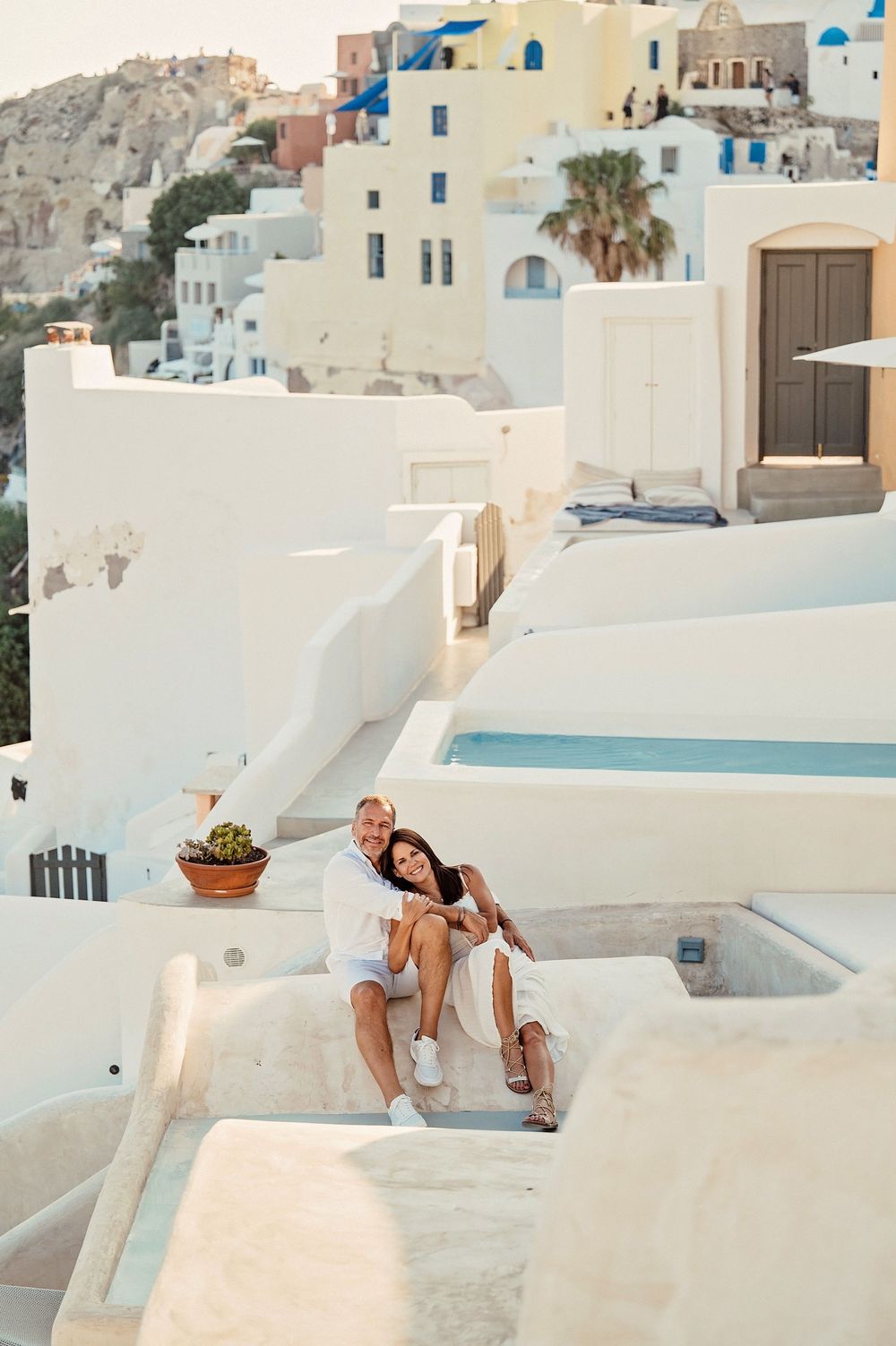 A romantic moment on the white rooftops of Santorini with traditional Cycladic architecture in view.