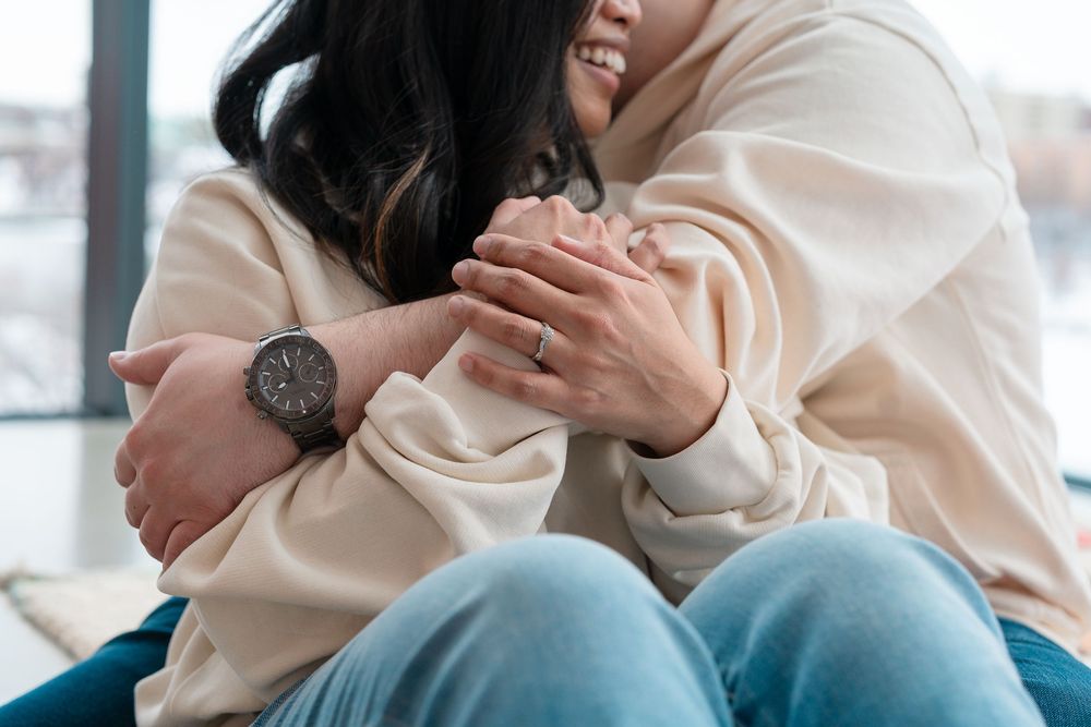 Close up of couple wearing matching cream sweaters sharing tender moment together.