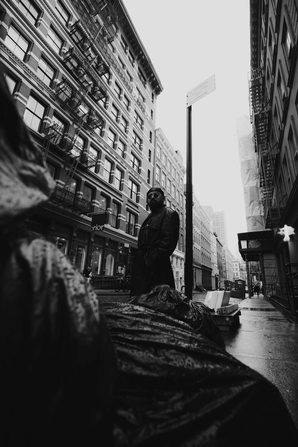 Dramatic black and white street photography capturing silhouette against urban architecture.