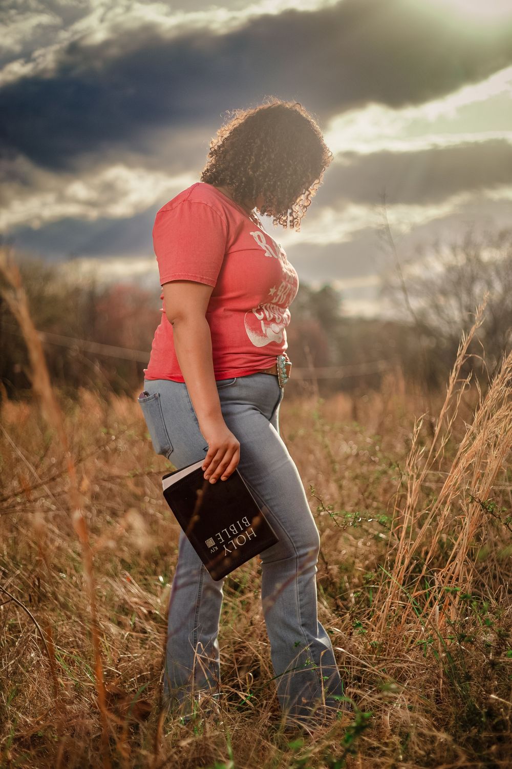 Dramatic sunset senior portrait in a Lincoln, Alabama field capturing the milestone of graduation.