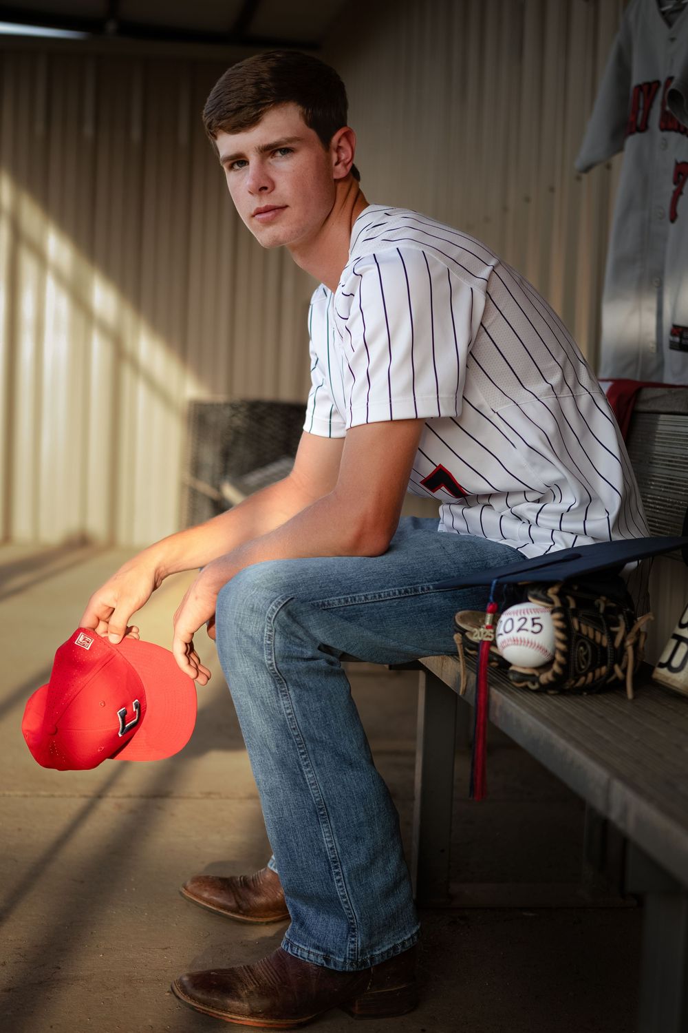High school baseball senior portrait in a Lincoln, Alabama dugout at golden hour. Lineville, Ashland Alabama