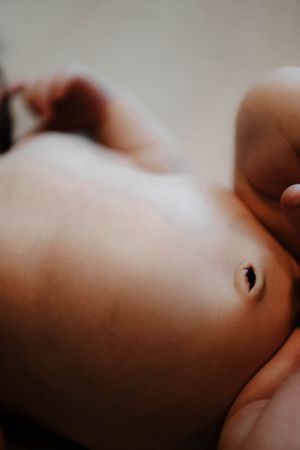 A baby lying down in a soft, dreamy lighting with delicate skin tones.