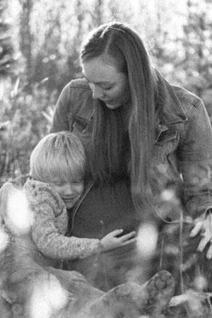 Family sharing tender moments together in a forest setting.