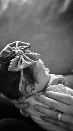 Black and white portrait of a sleeping figure with a decorative hair bow and ring.