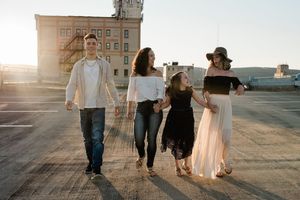 Family walking together at sunset creating long shadows on concrete.