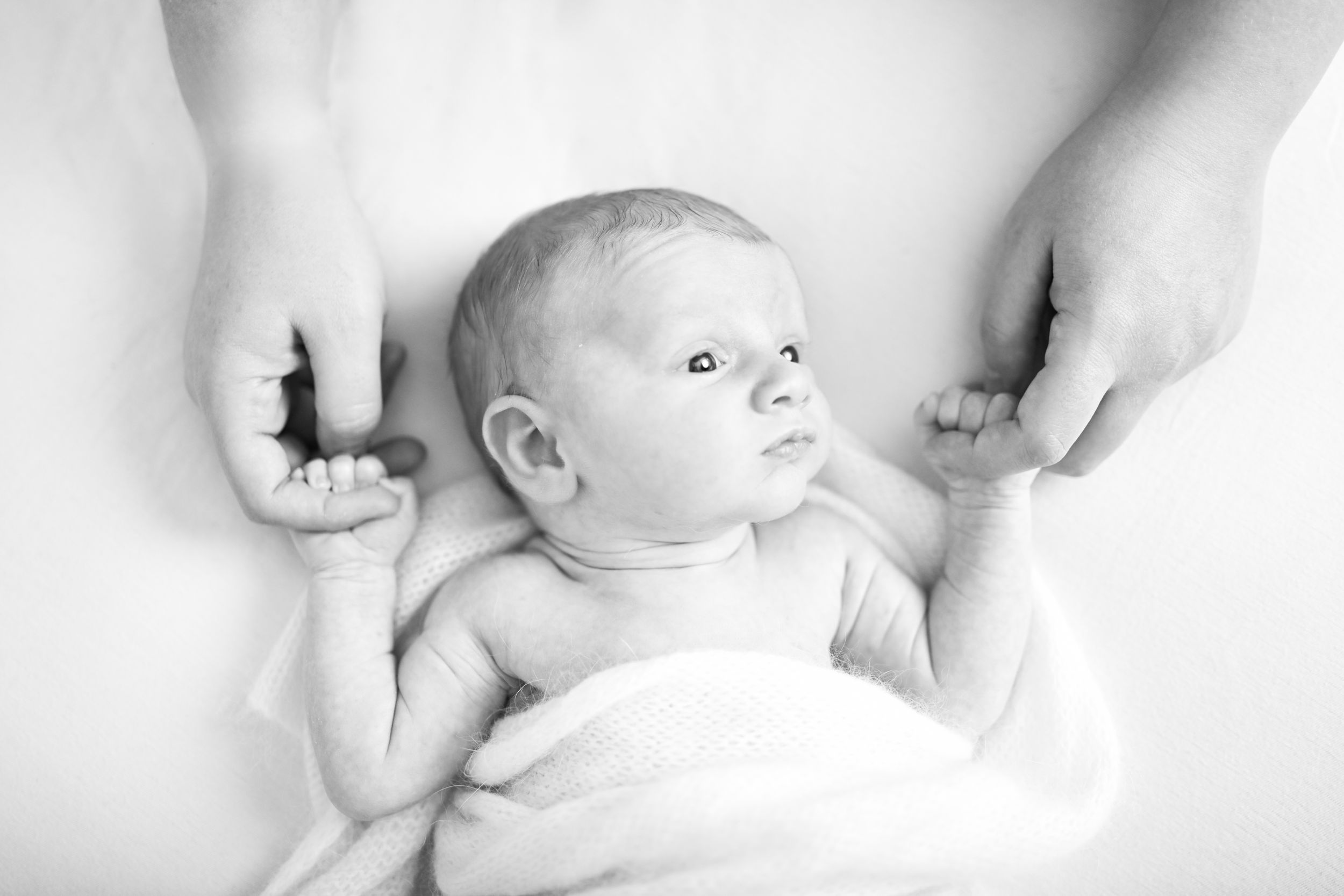 Playful family moments captured on white bedding with natural light and joyful interactions.
