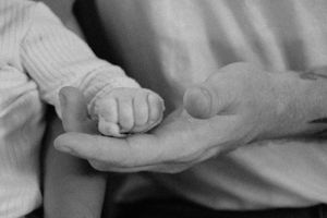 Artistic black and white photo showing intimate details of hands and fabric.
