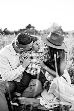 Black and white sequence of couple sharing intimate moments in field wearing western attire.