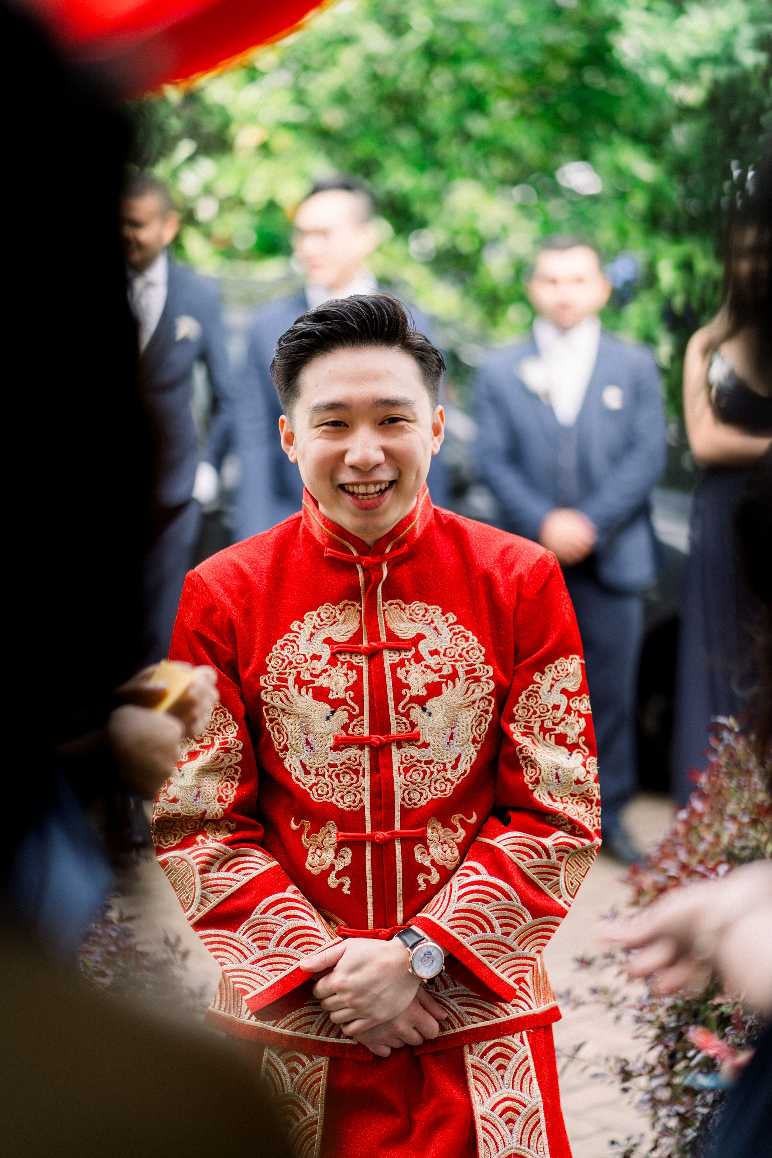 Groom being welcomed inside to see his bride after completing Chuangmen challenges during their traditional Chinese wedding in Nottingham.
