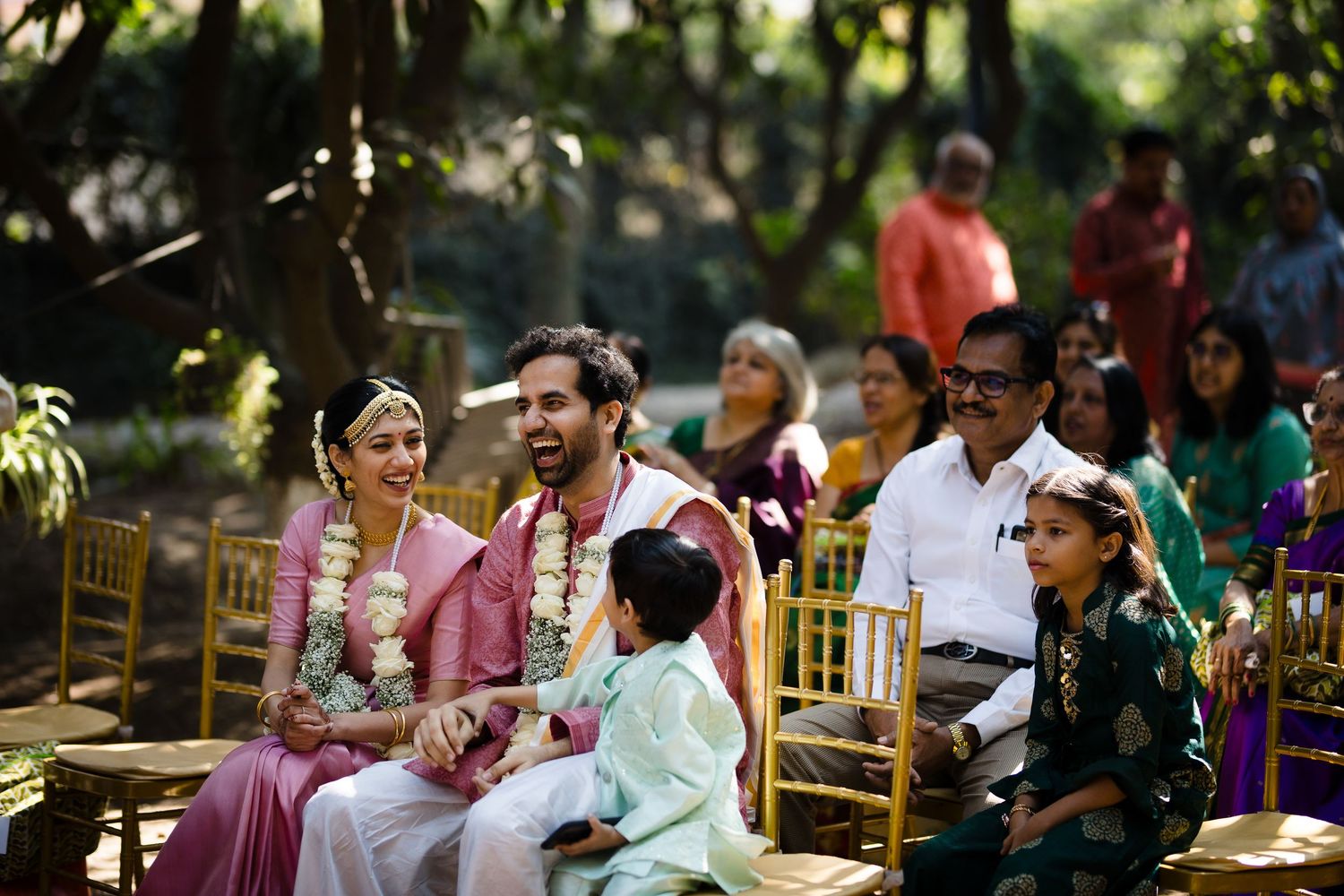 Wedding guests gathered at an outdoor ceremony with traditional decor and seating.