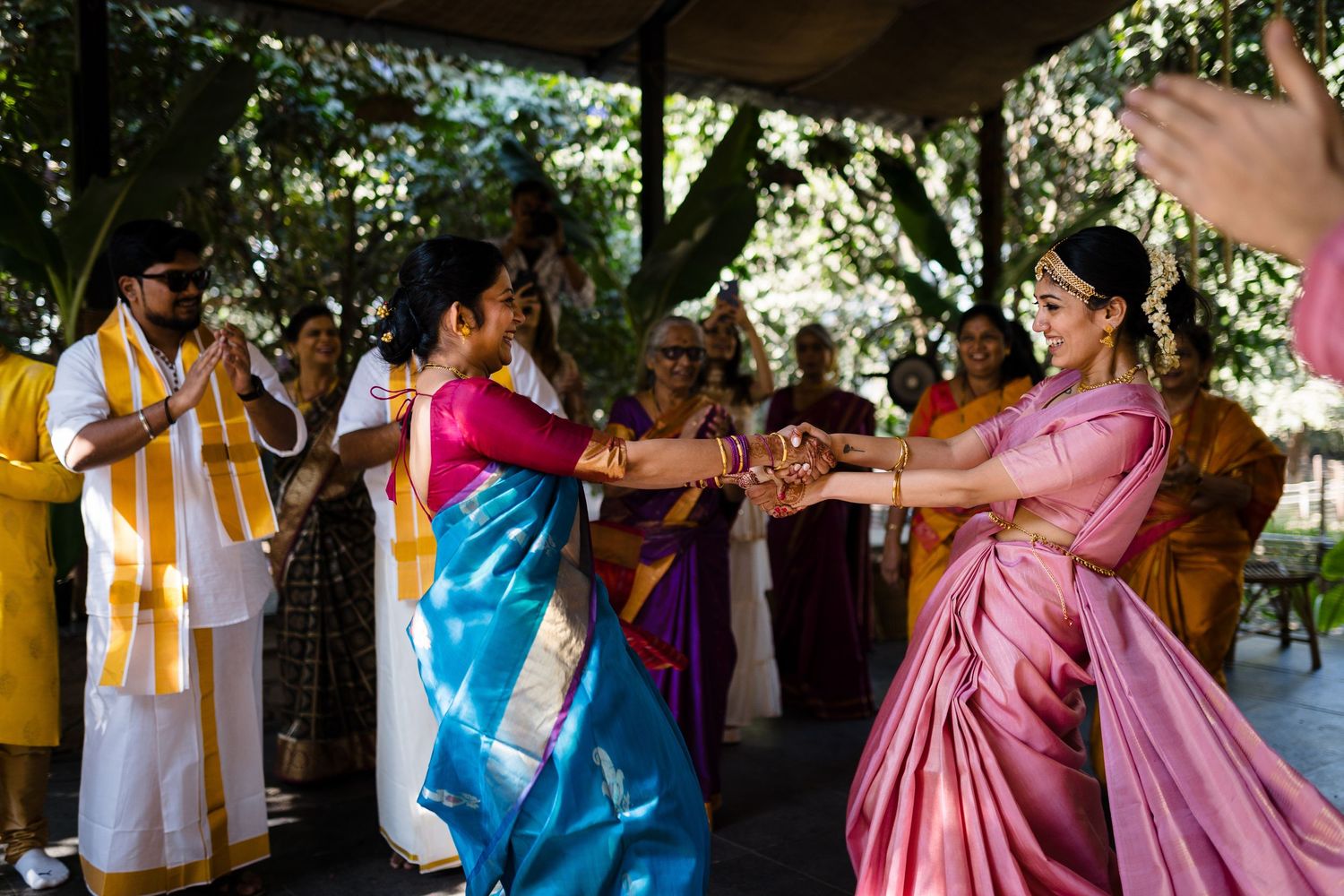 People in colorful traditional clothing dancing at an outdoor celebration.