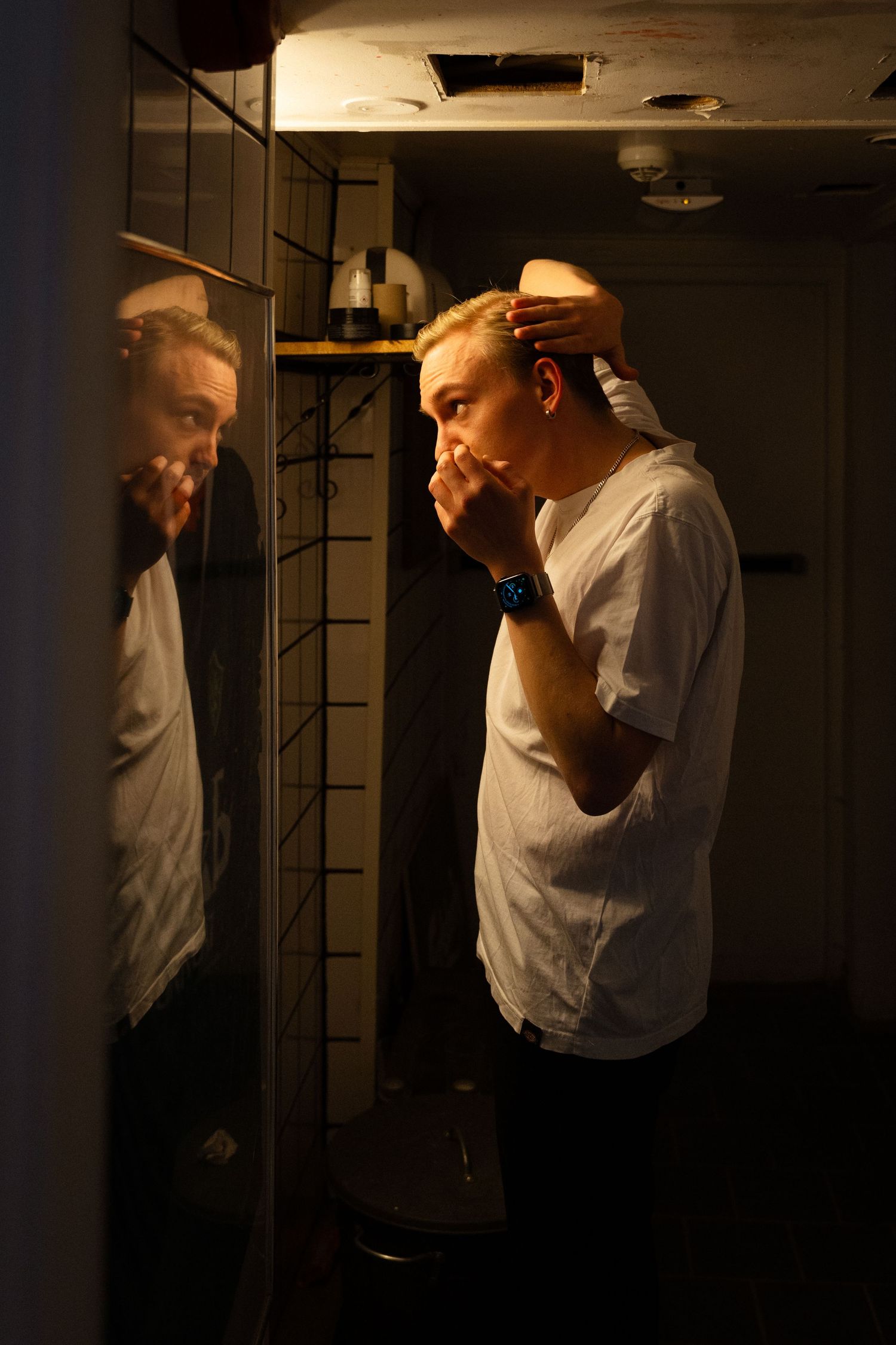 Dokumentärfotografi av bandmedlem som gör sig klar och kammar håret inför spelning. Fotograf i borlänge Gabriel Alenius.