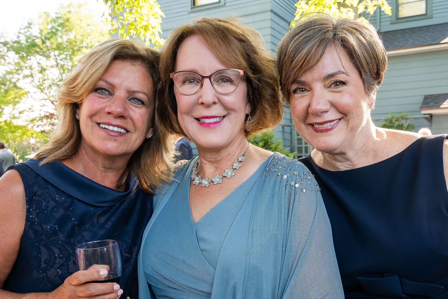 Close-up of three beautiful woman caught candidly at a wedding reception at The Sheraton Inn, Skaneateles, The Finger Lakes, 2024.