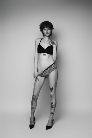 Black and white artistic portraits showing legs with tattoos against a minimalist background.