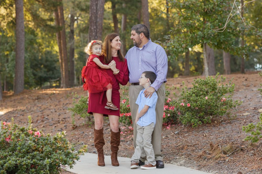 Family walking together on an autumn trail surrounded by fall foliage.