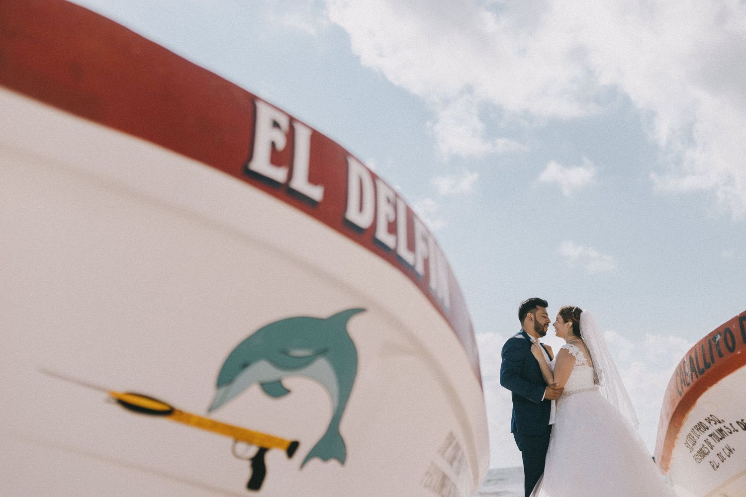 Wedding party posing on a boat dock with red and white decor details.