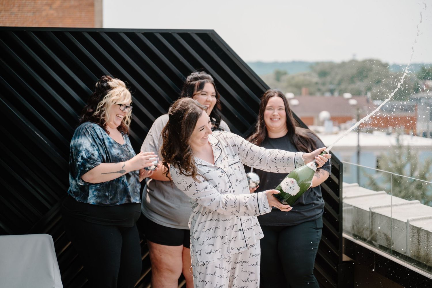 Friends enjoying wine and snacks on a rooftop patio during a sunset gathering.