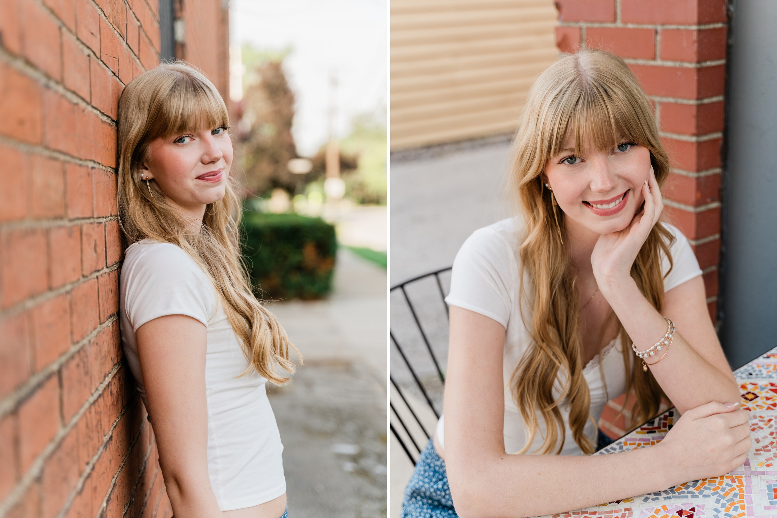 Woman with blonde hair in blue and white floral dress smiles while sitting against brick wall outdoors.