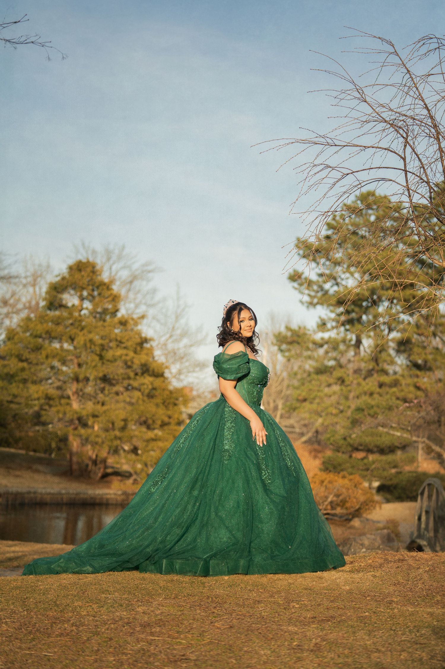 A pink ballgown with floral details and tulle skirt photographed in a dreamy forest setting.