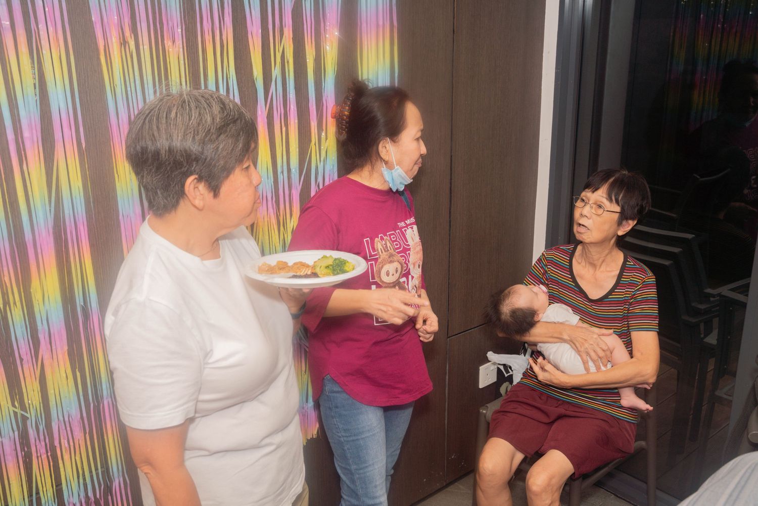 Group of people seated at tables enjoying a social gathering in an indoor setting.