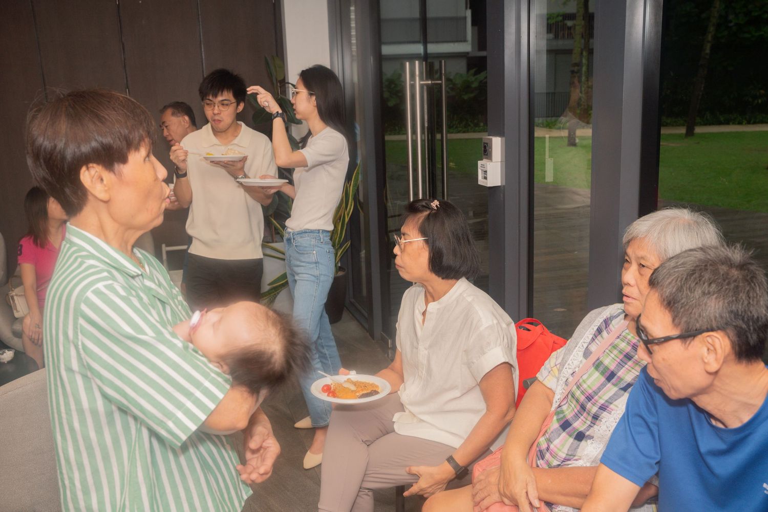 A group of people gather casually indoors for what appears to be a social gathering or party.